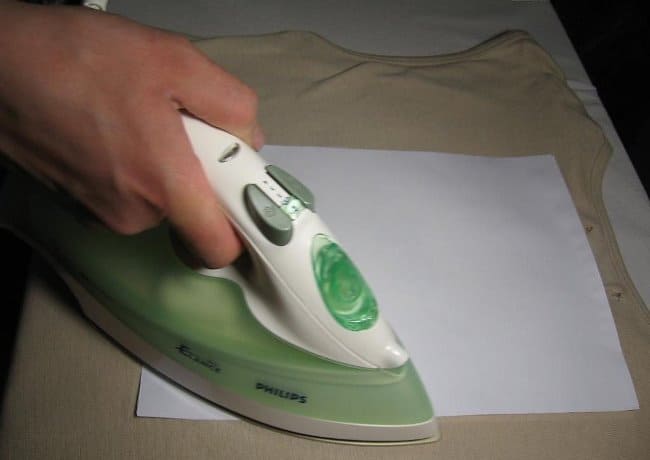 Чтобы не испортить утюг, накройте поврежденное место бумагой