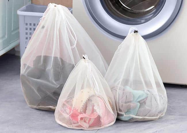Перед закладкой в барабан рекомендуется поместить одежду в специальные мешки или чехлы для стирки